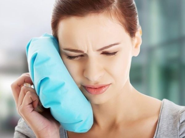 Apply a cold compress to the outside of your cheek near the sensitive tooth for temporary relief