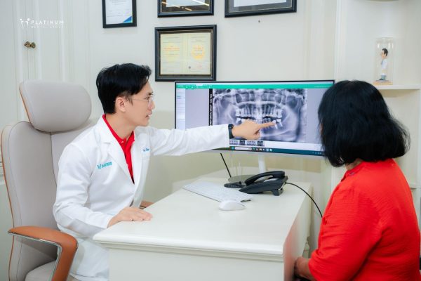 Bác sĩ kiểm tra sau cấy ghép Implant đảm bảo trụ tích hợp đúng vị trí và chắc chắn và tư vấn cho bệnh nhân cách chăm sóc răng miệng sau khi cấy trụ Implant